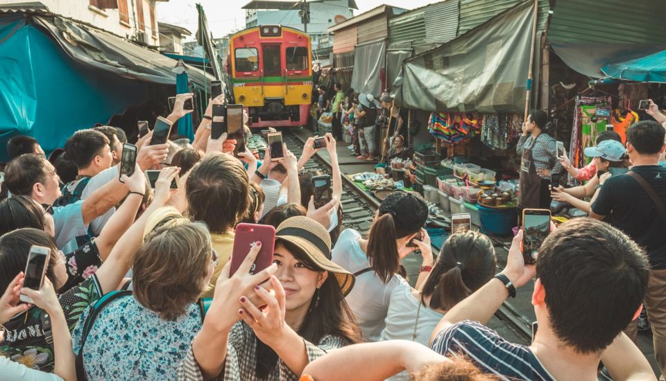 SE Asian tourists wait for a train